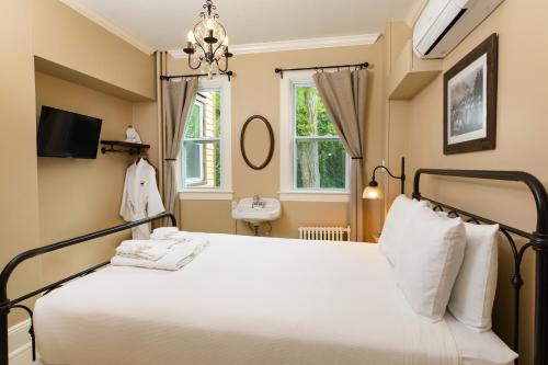 um quarto com uma cama e um lavatório em Pine Cottage Bed & Breakfast em Mackinac Island