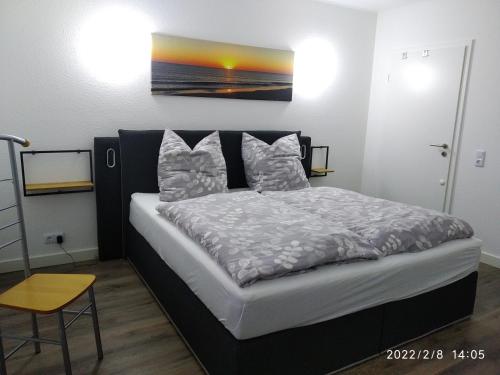 a bedroom with a bed with a painting on the wall at Ferienwohnung Christine in Jever