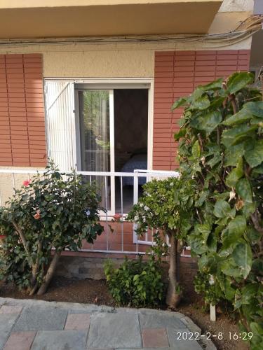 una casa con una ventana y dos arbustos en Habitación independiente céntrica en Fuengirola
