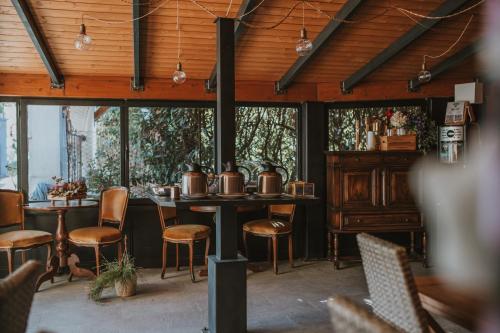un restaurante con mesa, sillas y ventanas en Resort Bacca Blu en Bricherasio