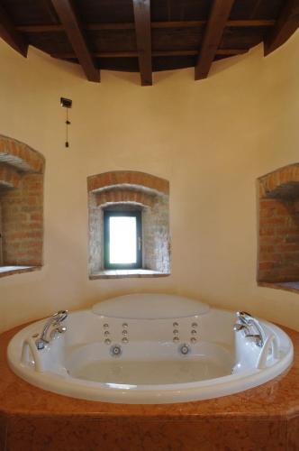 a large bath tub in a bathroom with a window at Hotel Torre di San Martino in Gazzola Di Rivalta