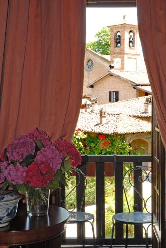 a vase of flowers sitting on a table on a balcony at Hotel Torre di San Martino in Gazzola Di Rivalta