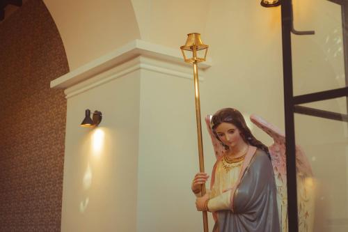 a statue of a woman holding a stick at San Juan Suites in Sucre