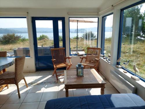 a room with two chairs and a table and windows at Villa in Le Faou with Panoramic Sea Views in Hanvec