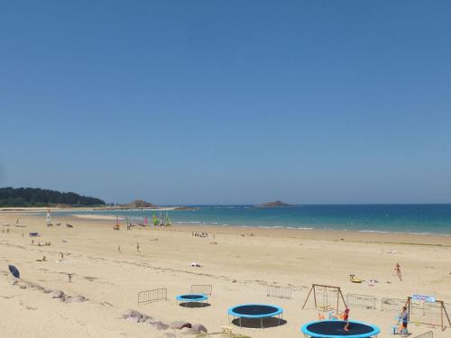 a beach with a bunch of people and the ocean at Stone House in Plurien near Sandy Beaches in Plurien