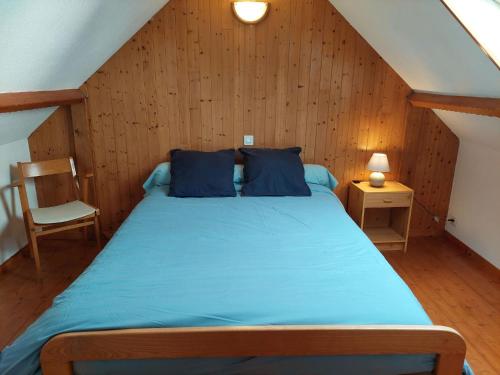 a bedroom with a blue bed in a attic at Stone House in Brittany near Sandy Beaches in Landéda