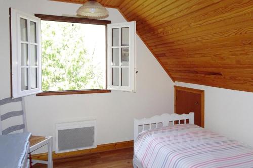 1 dormitorio con cama y ventana en Cottage, Penestin, en Pénestin