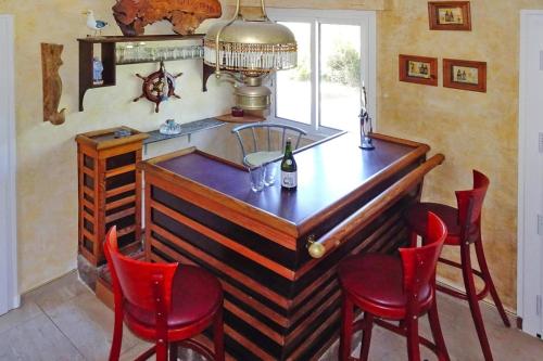 - un bar dans une salle avec des chaises rouges et un comptoir dans l'établissement Holiday Home by Brehat Island & Sea Views, à Ploubazlanec