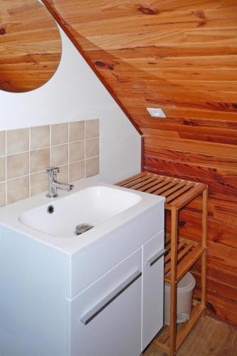 La salle de bains est pourvue d'un lavabo blanc et d'un plafond en bois. dans l'établissement Holiday Home in Plouarzel near Sandy Beach, à Plouarzel
