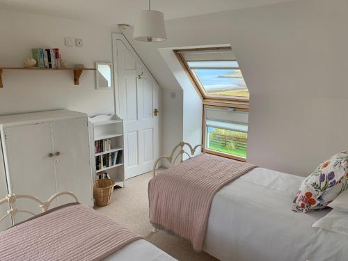 En eller flere senge i et værelse på Driftwood Cottage