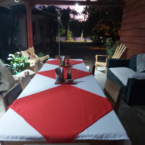a table with a red and white umbrella on a patio at Cabañas Daneysha in Tortuguero