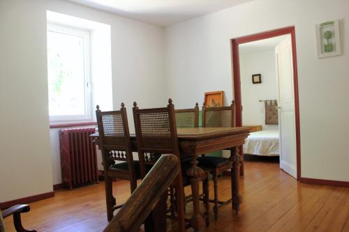 ein Esszimmer mit einem Tisch und Stühlen sowie ein Schlafzimmer in der Unterkunft Lou Prat in Meyrueis