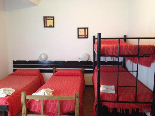 2 literas en una habitación con sábanas rojas en Hotel Mediterraneo en Villa Carlos Paz