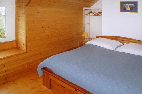1 dormitorio con 1 cama en una habitación de madera en Cottage, Plouhinec, en Plouhinec