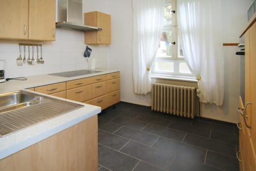 una pequeña cocina con fregadero y ventana en Cottage, Schorfheide, en Schorfheide