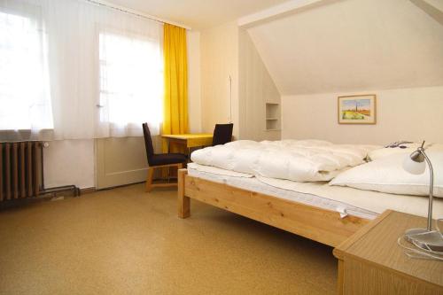 1 dormitorio con cama, escritorio y ventana en Cottage, Schorfheide, en Schorfheide
