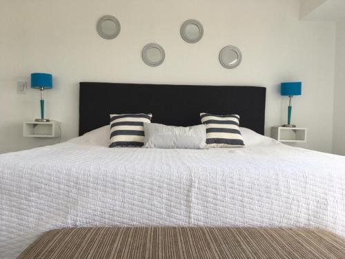 Un dormitorio con una cama blanca con almohadas. en Las Piedritas Monoambiente Vista en Las Grutas