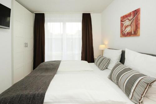 ein Schlafzimmer mit einem großen weißen Bett und einem Fenster in der Unterkunft Apartment in Lissendorf with a terrace in Lissendorf