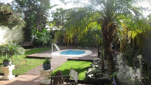 a backyard with a swimming pool and a palm tree at Casa Bambu, alquiler de corta estadia in Ciudad de la Costa