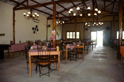 een eetkamer met tafels en stoelen en kroonluchters bij Hotel Fazenda Chiminelli in Cachoeiras de Macacu
