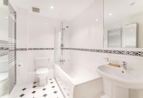 a white bathroom with a toilet and a sink at Strand House- Long Stays only in York