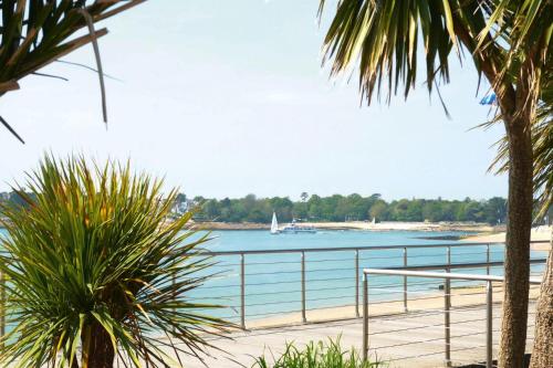 - une vue sur la plage avec un bateau dans l'eau dans l'établissement Apartment in Fouesnant by Sandy Cove, à Fouesnant