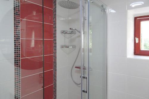 La salle de bains est pourvue d'une douche et d'une porte en verre. dans l'établissement Cottage, Buguélès-Penvénan, à Penvénan