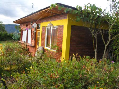 a small house in the middle of a garden at Hospedaje Gratitud Guatavita in Guatavita