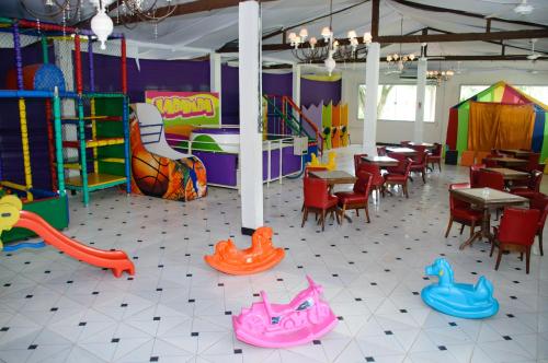 um restaurante com mesas e cadeiras e uma área recreativa em Hotel Fazenda Chiminelli em Cachoeiras de Macacu
