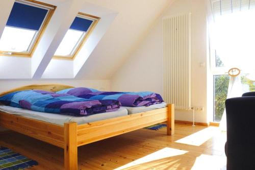ein Schlafzimmer mit einem Bett in einem Zimmer mit Fenstern in der Unterkunft Ferienhaus "Zum roten Adler", Storkow in Storkow