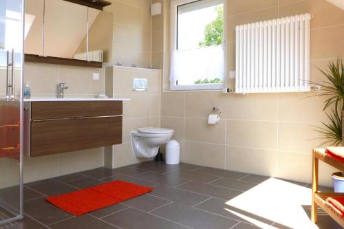ein Bad mit einem WC, einem Waschbecken und einem Fenster in der Unterkunft Ferienhaus "Zum roten Adler", Storkow in Storkow