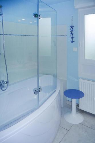 une salle de bain avec baignoire et douche en verre dans l'établissement Holiday Home in Brittany near Sandy Beaches, à Saint-Jean-du-Doigt