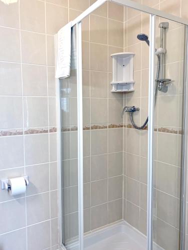 a shower with a glass door in a bathroom at The Earlsdale Bed and Breakfast in Ilfracombe