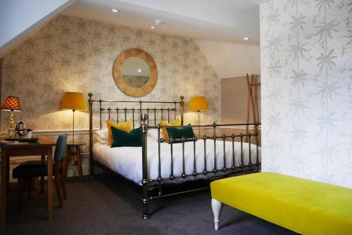a bedroom with a bed and a table and a mirror at The Fleece in Witney