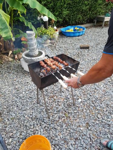 una persona está cocinando comida en una parrilla en marielies-urlaubsstube en Meißenheim