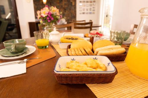 a table topped with baskets of food and orange juice at Pousada Mirante Dos Adelphos in Socorro