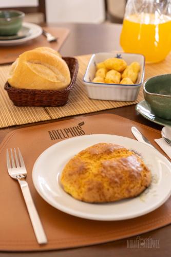 a table with a plate of food and a bowl of bread at Pousada Mirante Dos Adelphos in Socorro