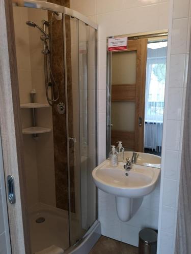 a bathroom with a sink and a shower at Antonina ***PensjonPrzyKortach*** in Szczawno-Zdrój