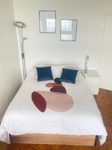 a bedroom with a white bed with blue pillows at Vivez La vue mer - Studio - Port de plaisance - Plage in Le Havre
