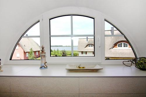 uma janela arqueada numa cozinha com um balcão branco em Ferienhaus Poseidon mit Meerblick am Breetzer Bodden in Vieregge em Vieregge