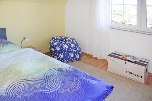 a bedroom with a bed and a chair and a window at Ferienhaus Poseidon mit Meerblick am Breetzer Bodden in Vieregge in Vieregge