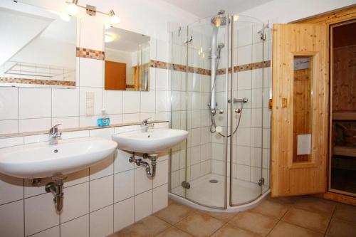 a bathroom with two sinks and a shower at Doppelhaushälfte Ostseehaus II, Trassenheide in Trassenheide