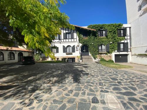 a cobblestone street in front of a white building at Hosteria del Bosque in Necochea