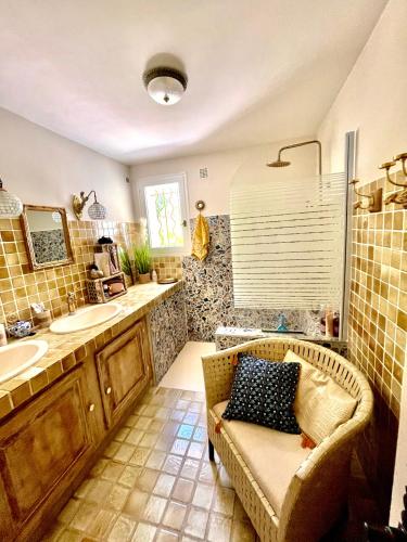 La salle de bains est pourvue d'un canapé, d'un lavabo et d'un miroir. dans l'établissement L'escale chambres d'hôtes et gîte, à Draguignan