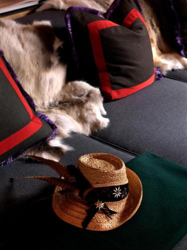 a dog laying on a couch with a hat on it at House of Hütter - Wachtelhof & SPA in Maria Alm am Steinernen Meer