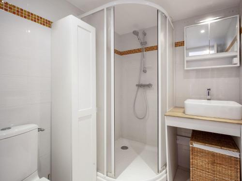 une salle de bain blanche avec une douche et un lavabo dans l'établissement Superbe studio face à la mer accès direct plage, à Biarritz