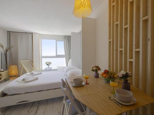 une chambre avec un lit et une table avec des fruits dessus dans l'établissement Superbe studio face à la mer accès direct plage, à Biarritz