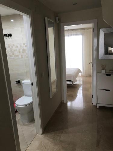 a bathroom with a toilet and a sink and a mirror at Apartamento El Eden Playa de Gandía in Playa de Gandia