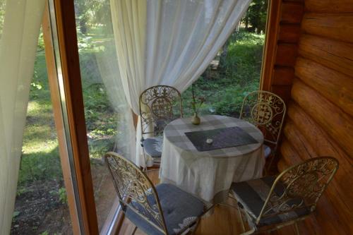 Holiday Home Bērzlejas في Upesgrīva: طاولة وكراسي على شرفة المنزل