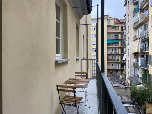 Top Living Apartments - Torino Centro في تورينو: كرسيين وطاولات على شرفة المبنى